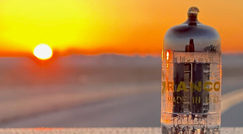 A vintage American tube set against the backdrop of a setting sun