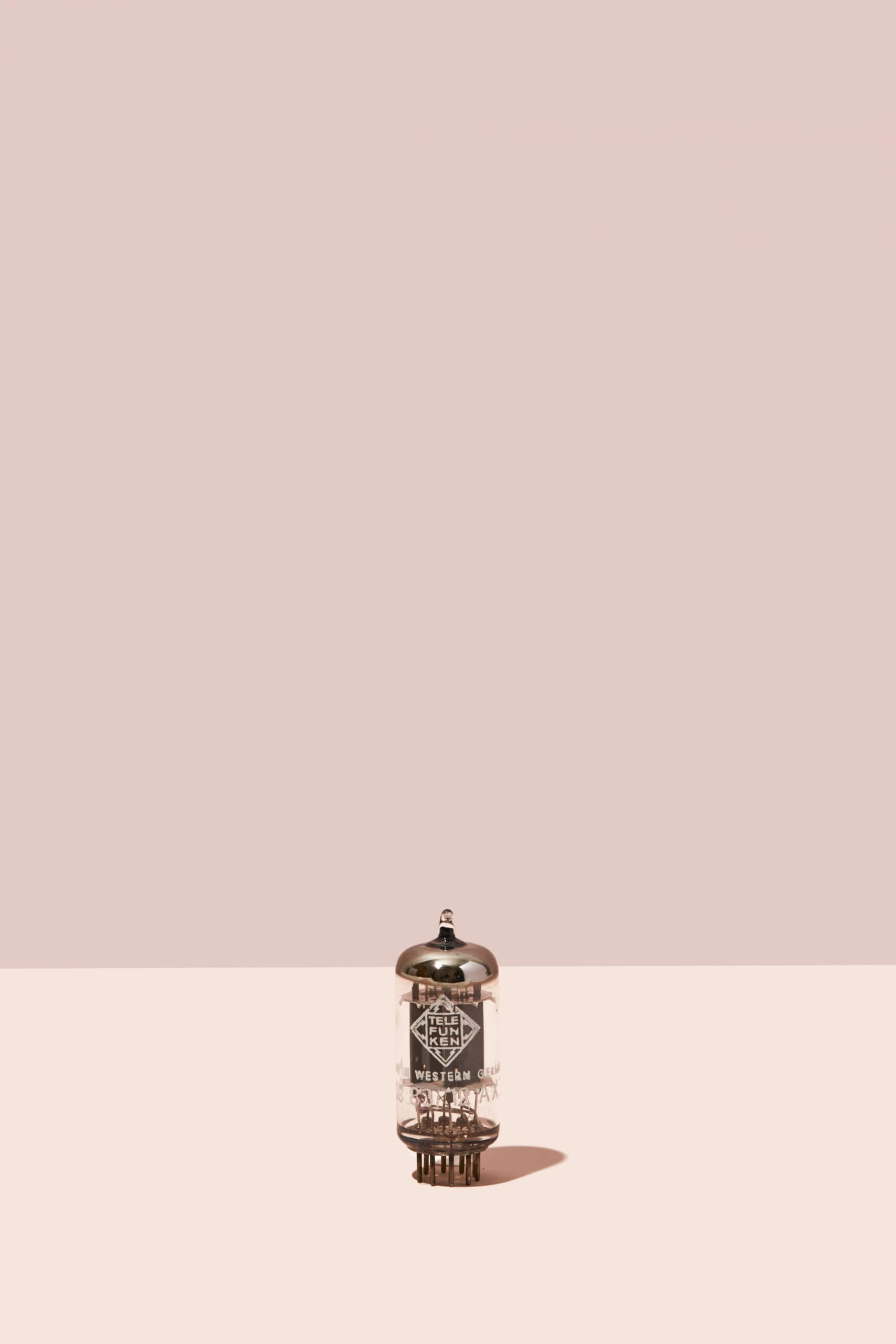 A vintage Telefunken tube against a two-tone beige background